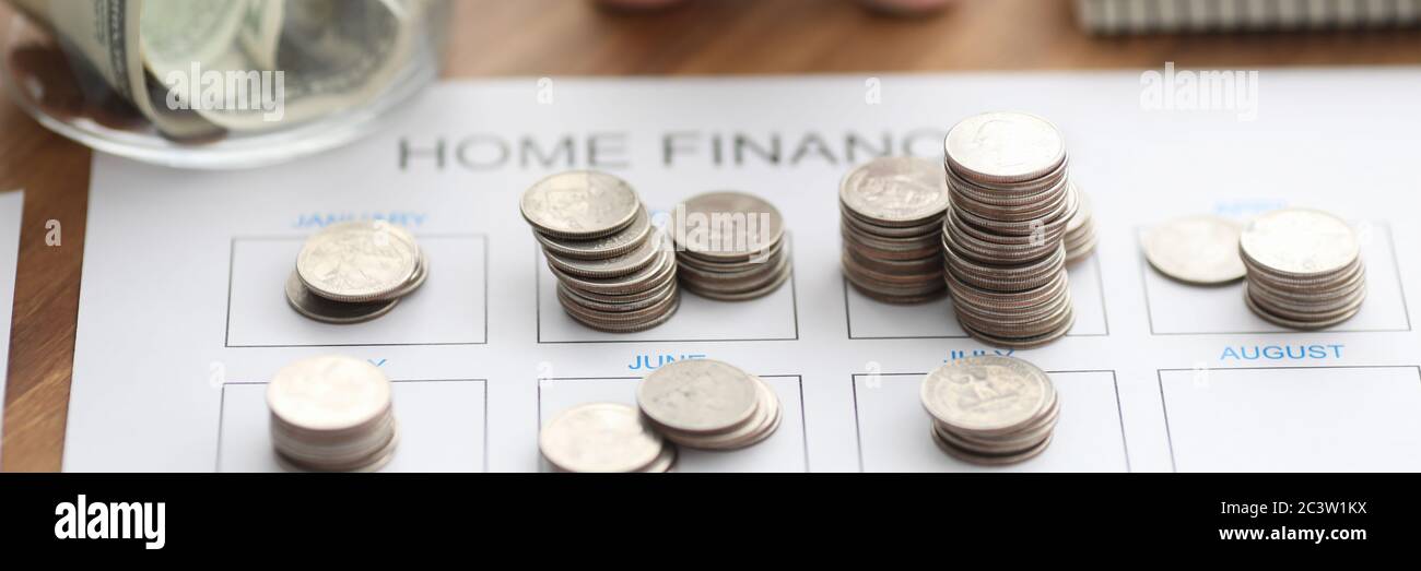 Münzen und Sparkassen liegen auf dem Finanzformular für Privathausmittel Stockfoto
