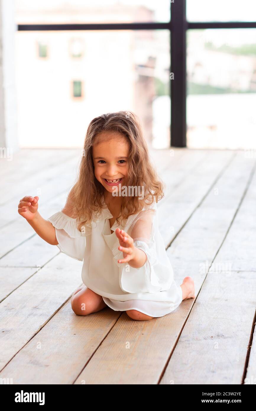 Charmante kleine Mädchen mit infantilen zerebralen Lähmung versuchen, zu sitzen und zu tanzen. Konzept der infantilen zerebralen Lähmung Stockfoto