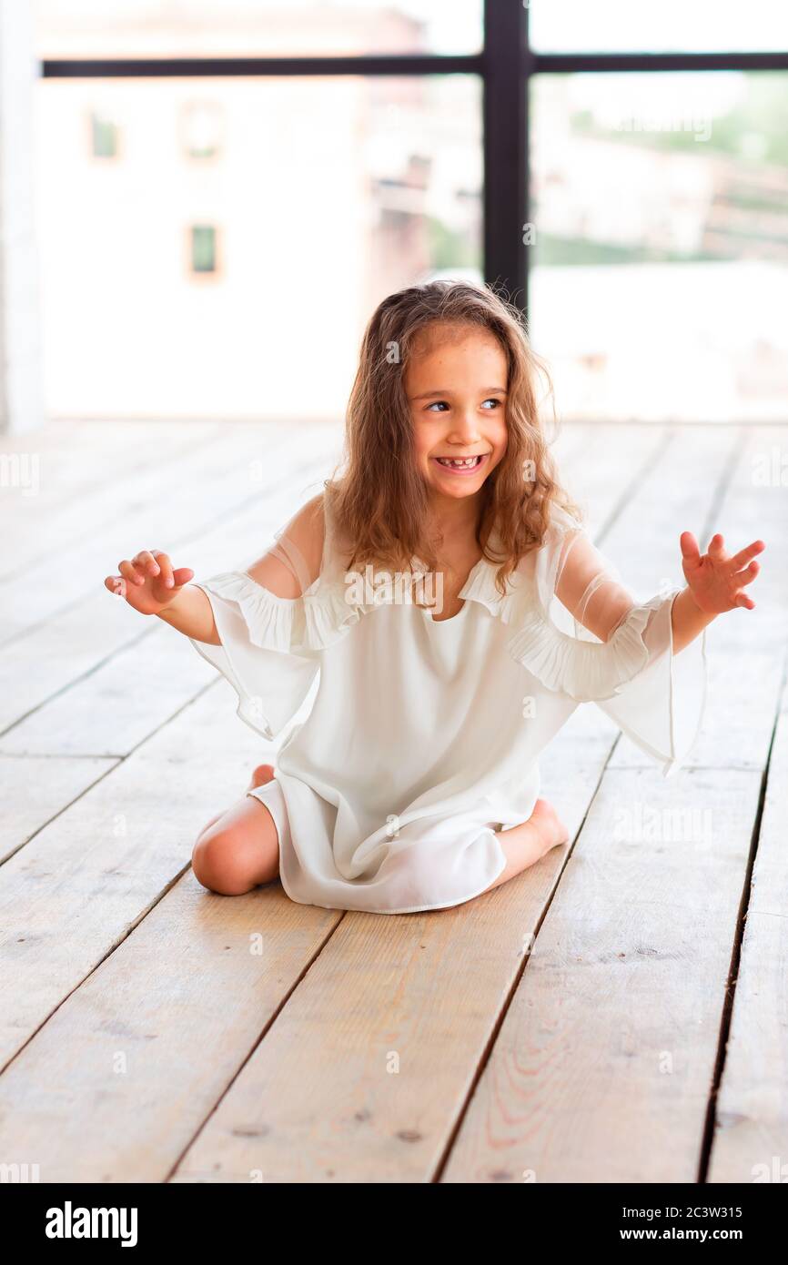 Charmante kleine Mädchen mit infantilen zerebralen Lähmung versuchen, zu sitzen und zu tanzen. Konzept der infantilen zerebralen Lähmung Stockfoto