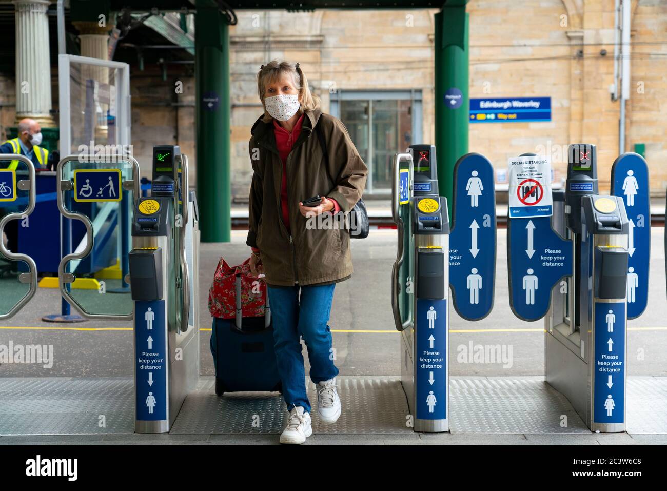 Edinburgh, Schottland, Großbritannien. Juni 2020. 22 Ab heute ist es für Passagiere obligatorisch, Gesichtsbezüge zu tragen, wenn sie auf der Eisenbahn und im öffentlichen Verkehr in Schottland unterwegs sind. Die Mitarbeiter der Waverley Station in Edinburgh verteilen kostenlose Gesichtsmasken und Handdesinfektionsmittel an die Passagiere. Iain Masterton/Alamy Live News Stockfoto