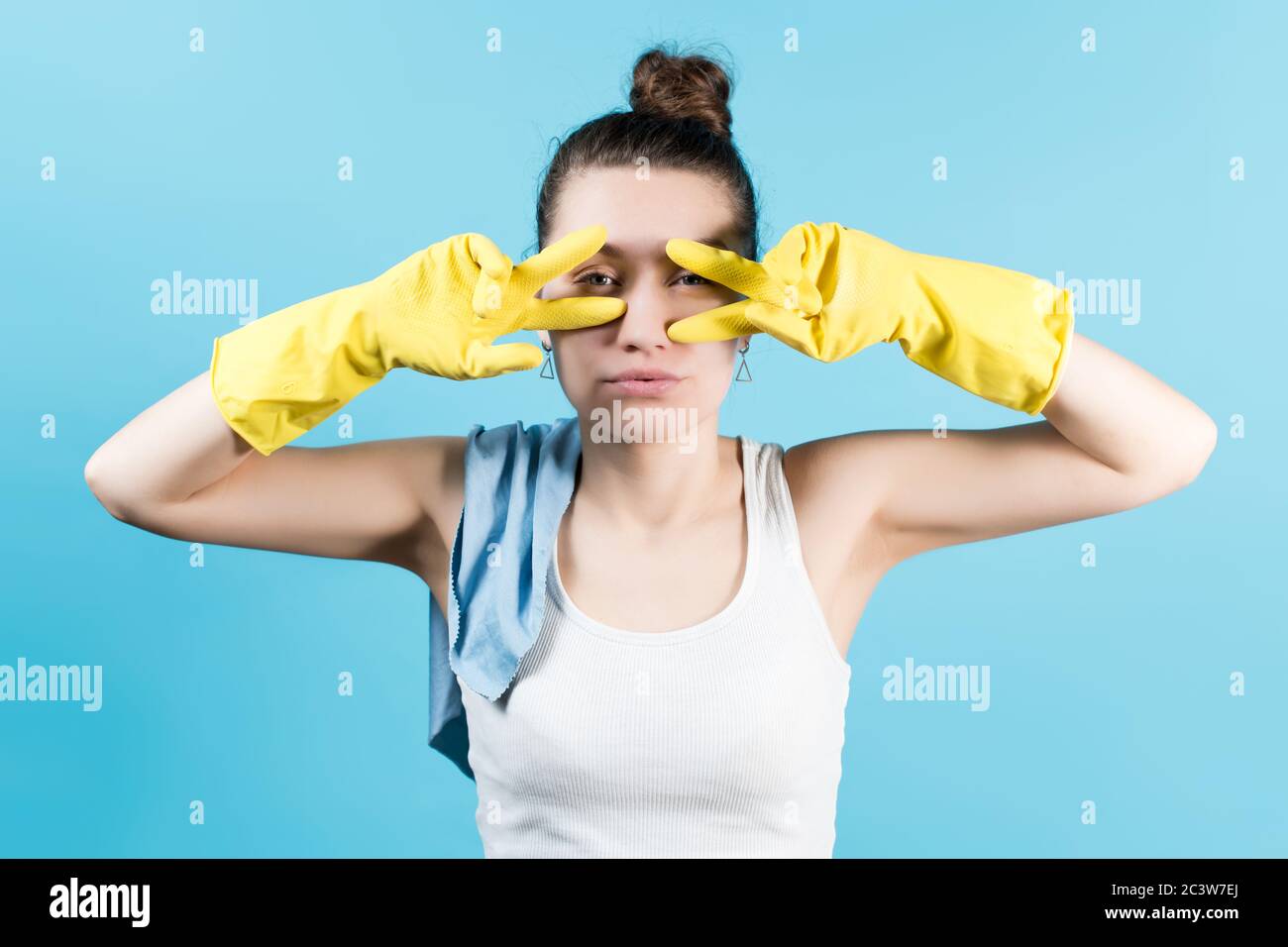 Junge Frau in einem T-Shirt herumtollend und posiert in Gelbe Handschuhe Stockfoto