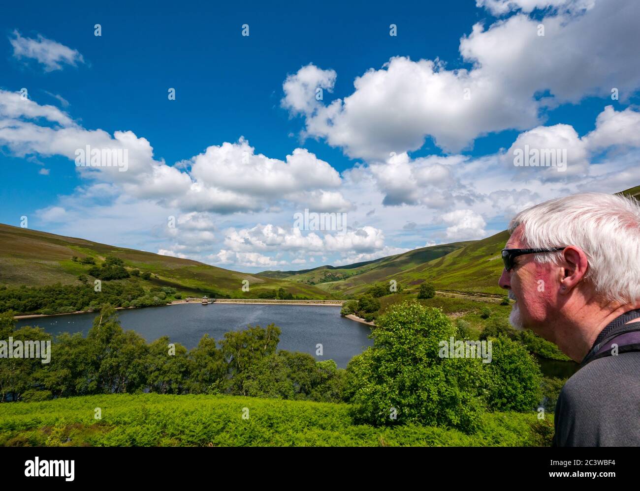 Senior Mann bewundernde Aussicht auf Scottish Water Hopes Reservoir, Lammermuir Hills, East Lothian, Schottland, Großbritannien Stockfoto