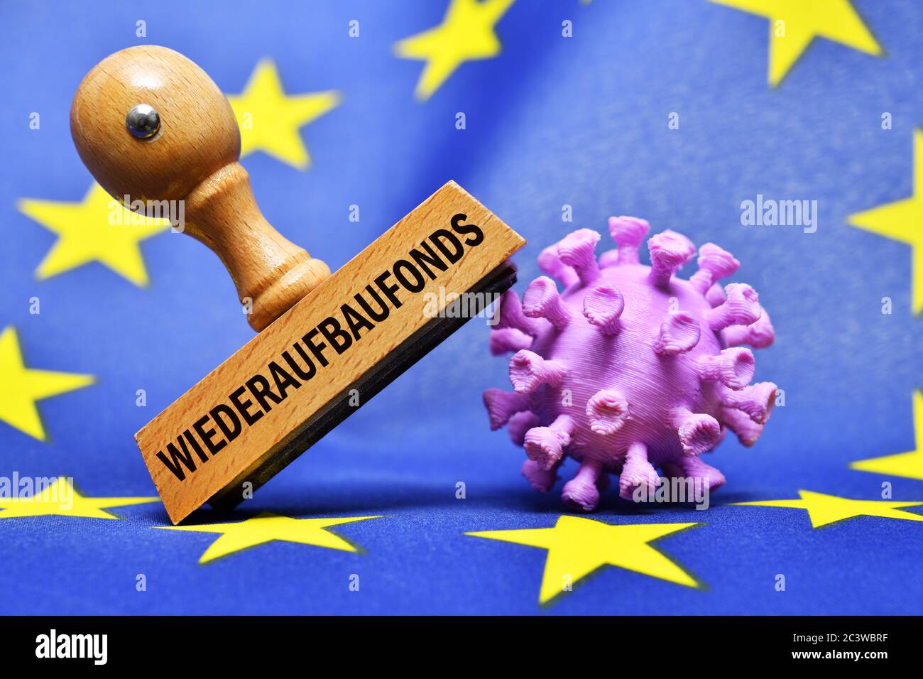 FOTOMONTAGE, Stempel mit Aufschrift EU Reconstruction Fund und Coronavirus Miniatur auf EU-Flagge, FOTOMONTAGE, Stempel mit Aufschrift EU-Wiederaufbau Stockfoto