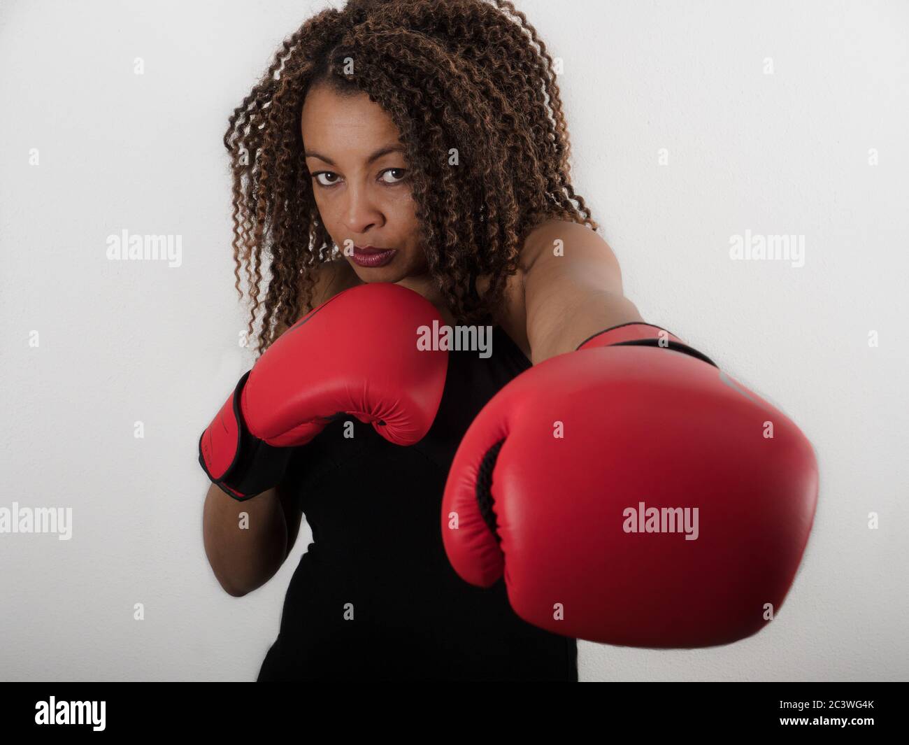 Horizontales Porträt einer afroamerikanischen Frau mit roten Boxhandschuhen Stockfoto