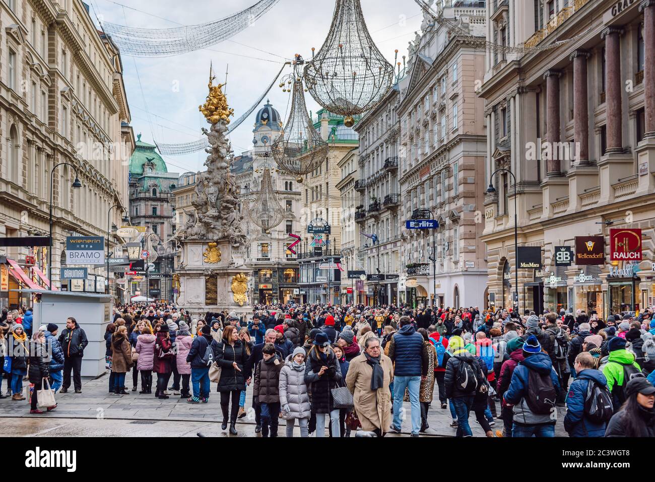 Die berühmte Grabenstraße mit vielen Touristen während der Weihnachtsferien, die Pestsäule in der Mitte der Straße, Wien, Österreich. Stockfoto