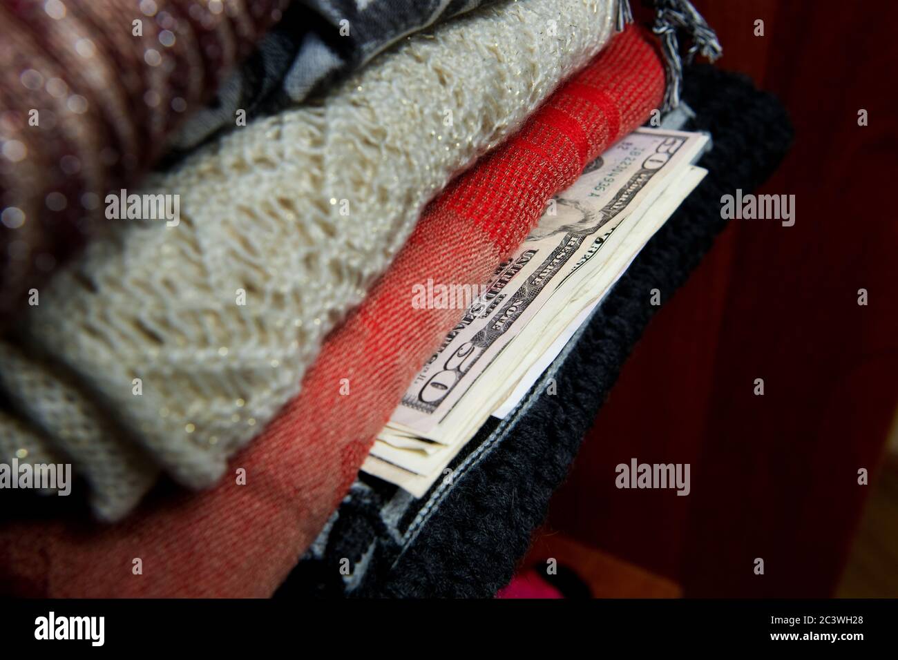 50 Dollar Rechnung und anderes Geld sind in Kleidung in einem Schrank versteckt. Stockfoto
