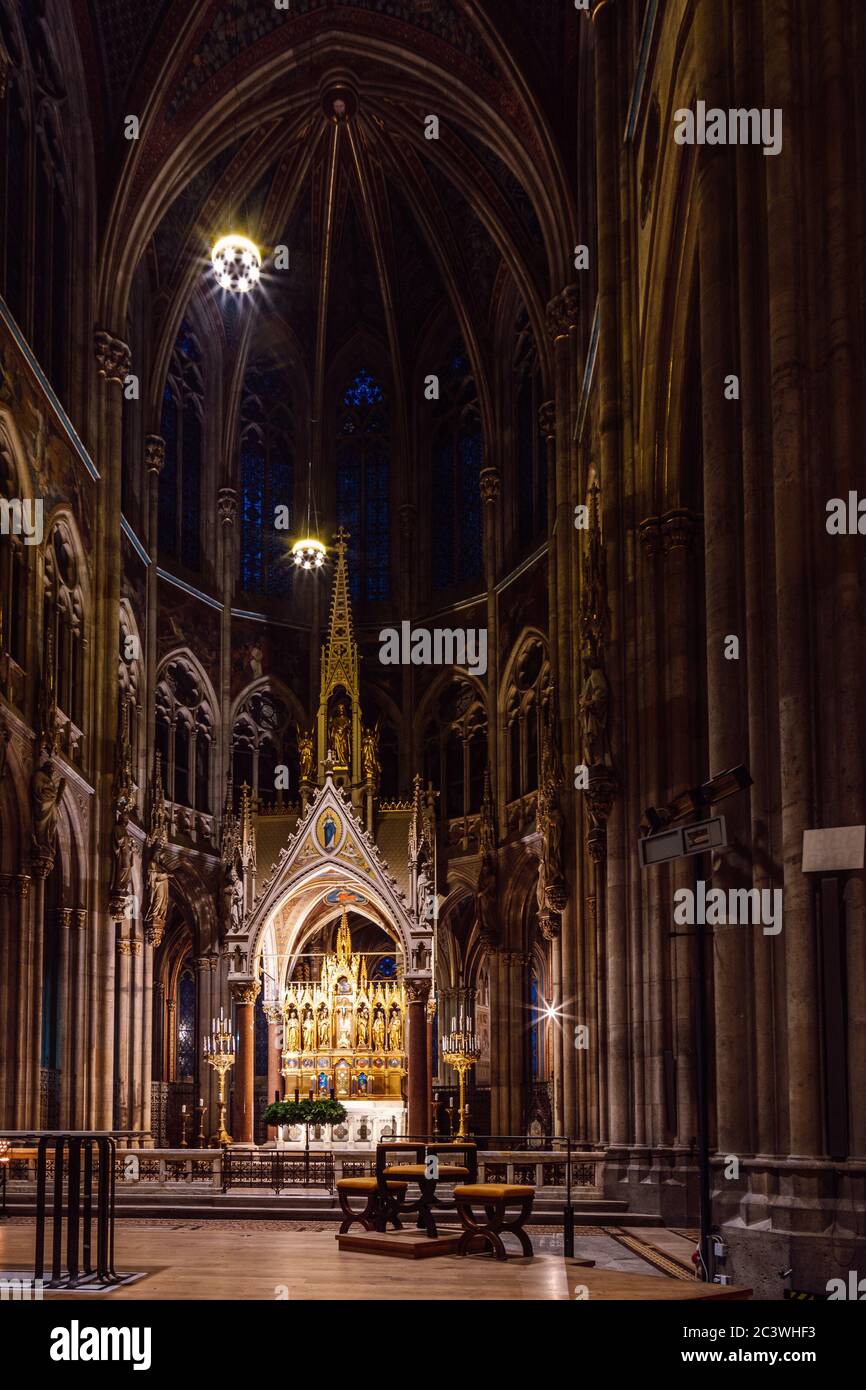 Innenansicht der Nacht mit Hochaltar, Chor, der neugotischen Votivkirche, Wien, Österreich. Stockfoto
