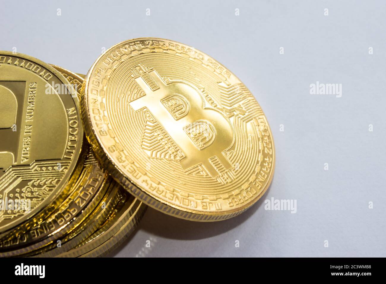 Auf blauem Hintergrund sind Goldmünzen einer digitalen Kryptowährung - Bitcoin Stockfoto