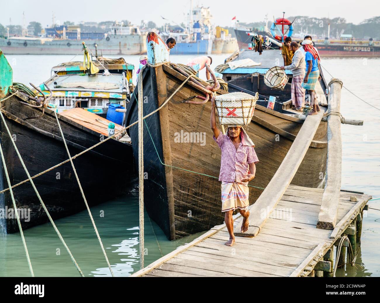 Chittagong, Bangladesch, 22. Dezember 2017: Manuelles Abladen von Salz aus einem Boot im Hafen des Karnaphuli River in Chittagong, Bangladesch Stockfoto