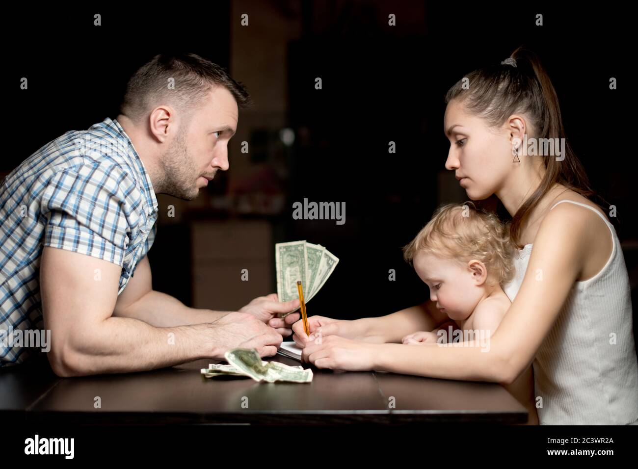 Eine junge Familie zählt Geld spät am Abend. Stockfoto