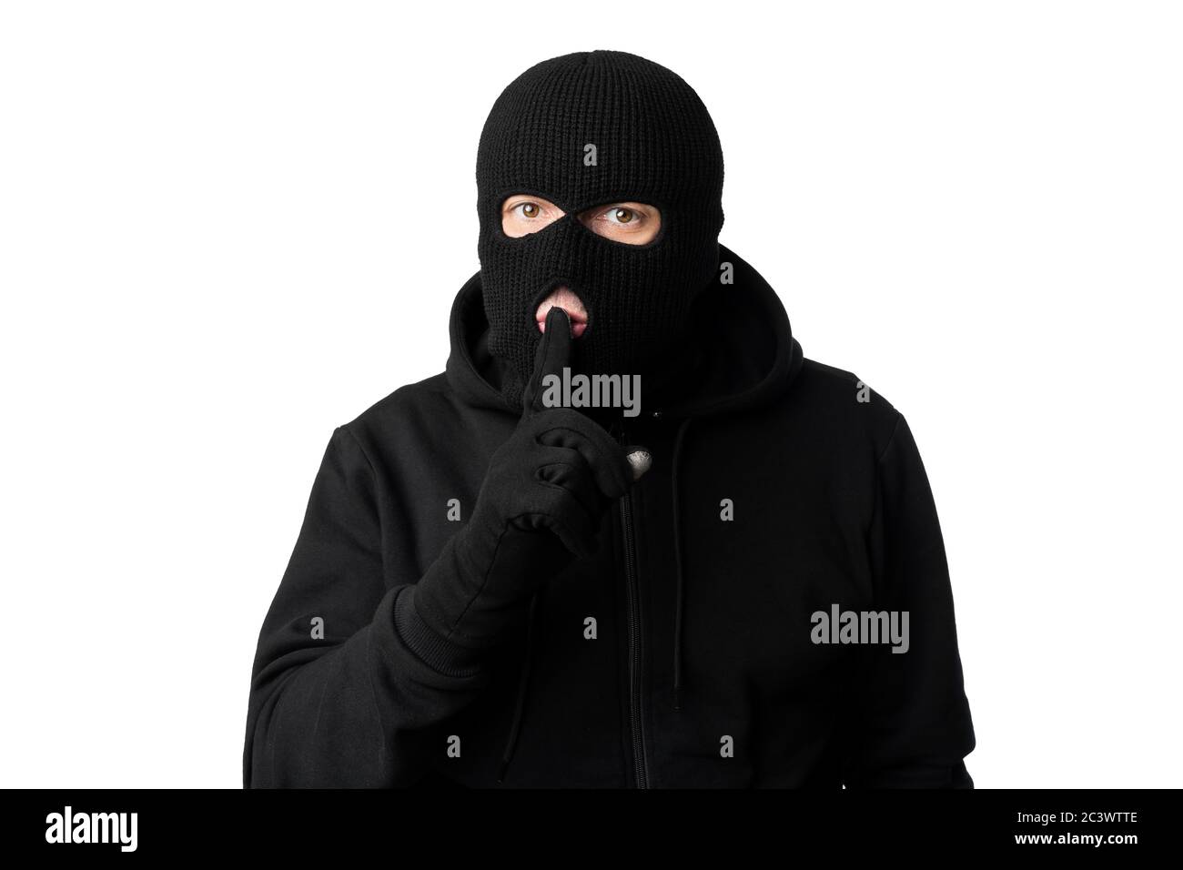 Dieb in schwarzer Balaclava hält Finger auf den Lippen Stockfoto