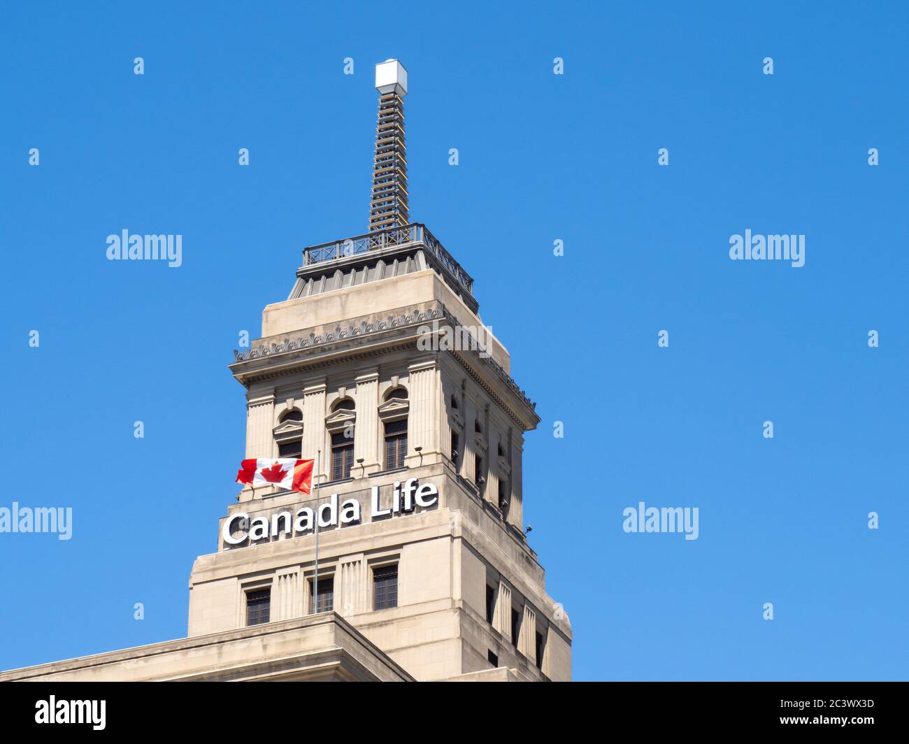Toronto Kanada 14. Juni 2020; das historische Canada Life Gebäude Wetterfeuer mit einer kanadischen Flagge, die auf einem tiefblauen Himmel fliegt Stockfoto