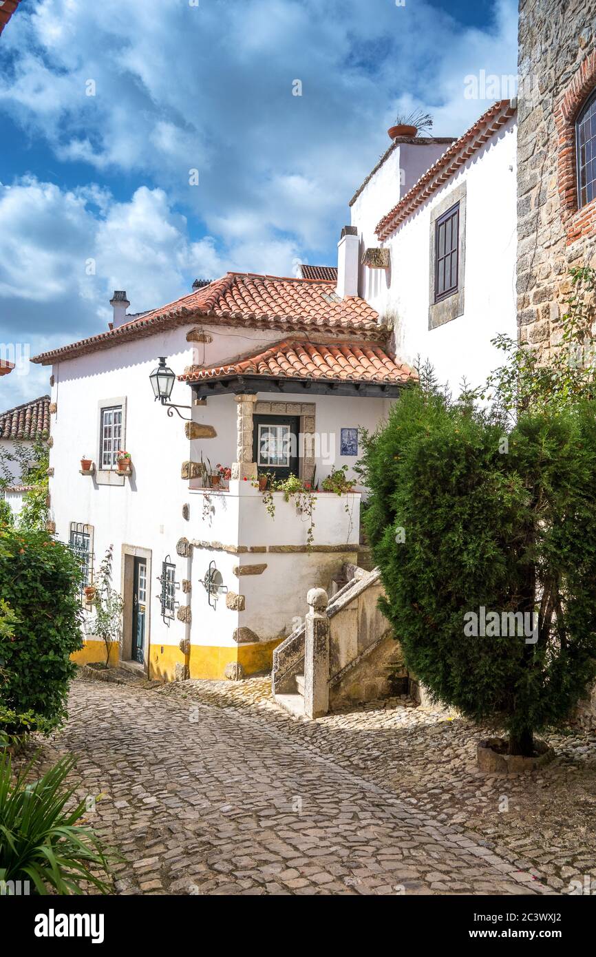 Blick auf gepflasterte enge Gassen im mittelalterlichen Obidos Portugal Stockfoto