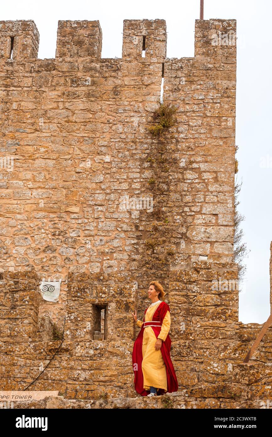 Frau in mittelalterlicher Tracht an der Burgmauer während des mittelalterlichen Festivals in Óbidos Portugal gekleidet Stockfoto