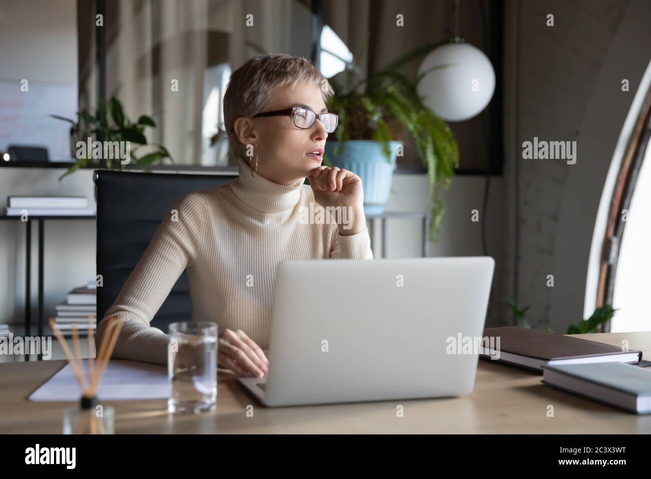 Geschäftsfrau, die neue kreative Ideen plant, sitzt am Schreibtisch im Büro Stockfoto