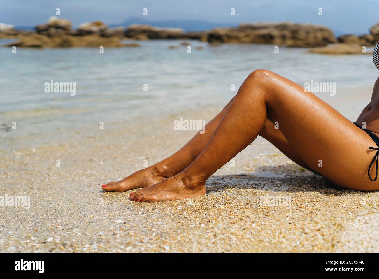 Gebräunte Frauen Beine in der Küste des Paradieses leeren Strand Stockfoto