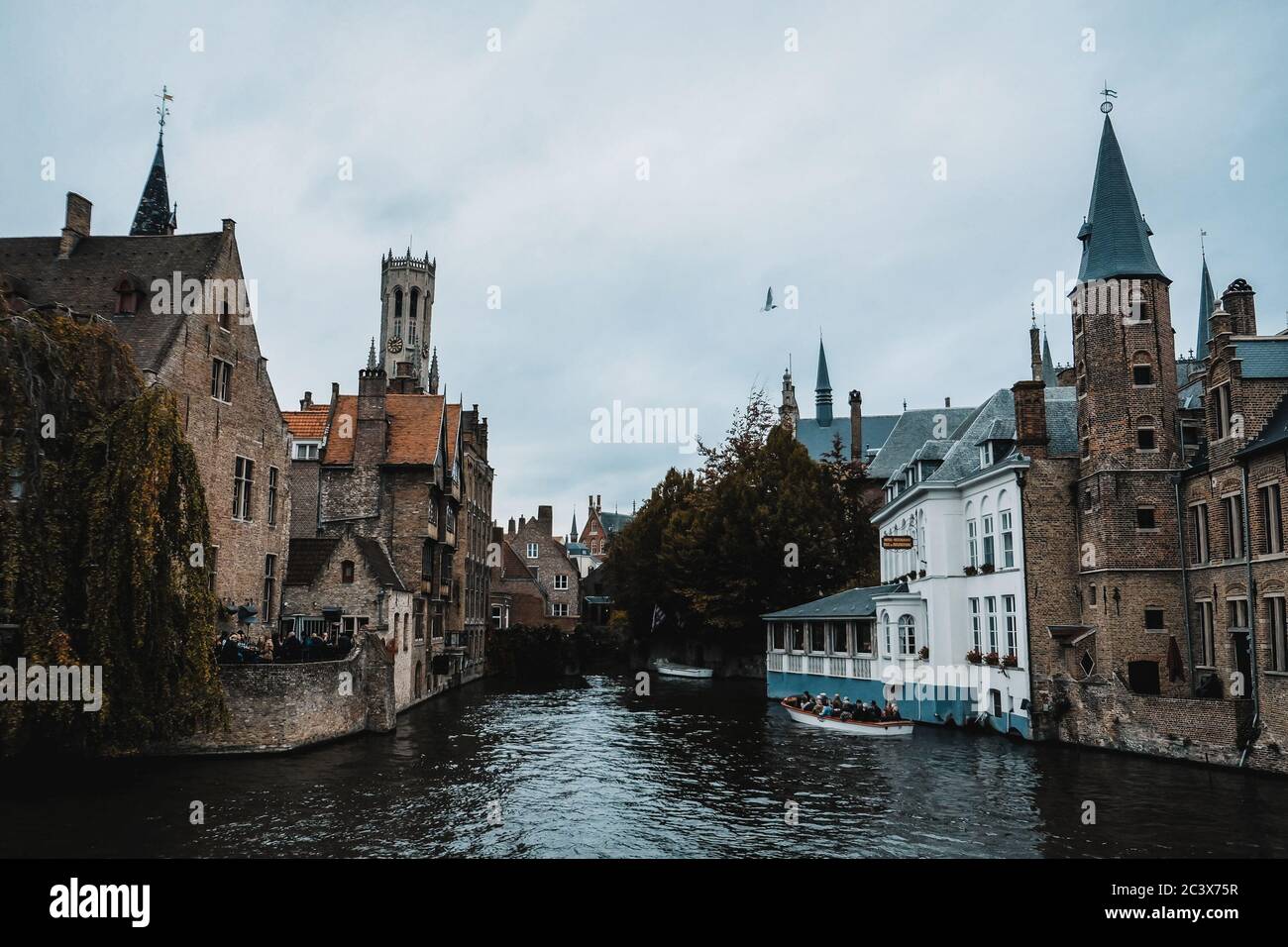 Brügge / Belgien - Oktober 2019: Boot voller Touristen auf einer Führung durch die mittelalterliche geheimnisvolle Stadt Brügge. UNESCO-Weltkulturerbe. Stockfoto