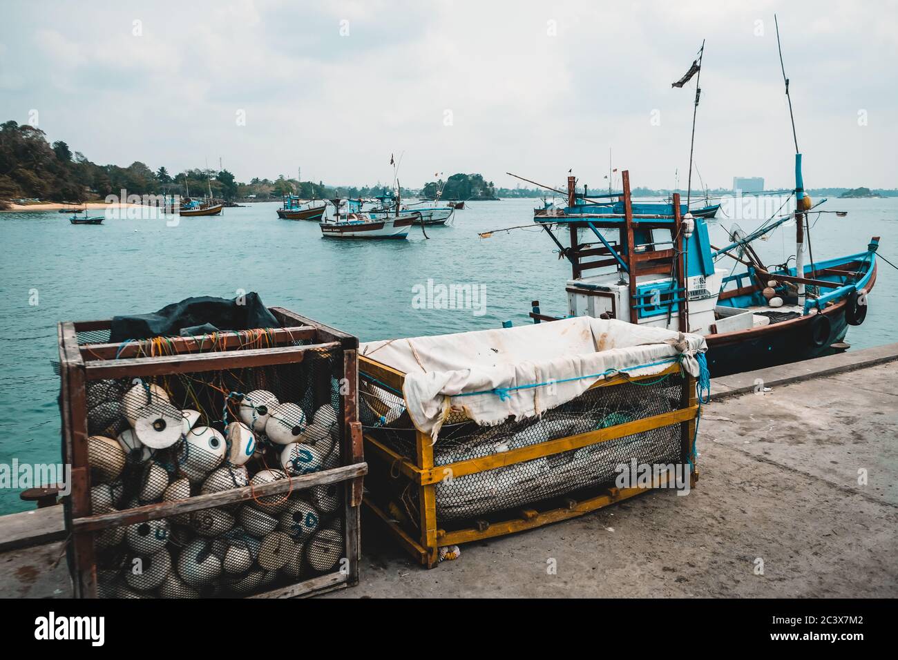 Fischtrawler und verschiedene Ausrüstung an einem Pier. Trawling als traditionelle lokale Handwerkskunst in Sri Lanka. Angelzubehör: Netz, Stroh, Seil. Stockfoto