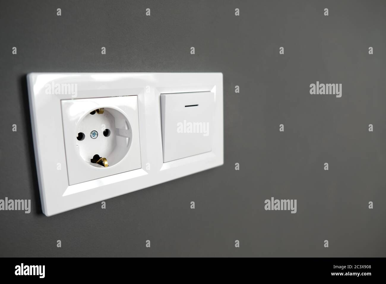 Weiße europäische Hochspannungsanschluss mit 220 W und Lichtschalter an  einer schwarzen Wand. Typische moderne Inneneinrichtung. Essentials in der  Renovierung und zu Hause Umbau Stockfotografie - Alamy