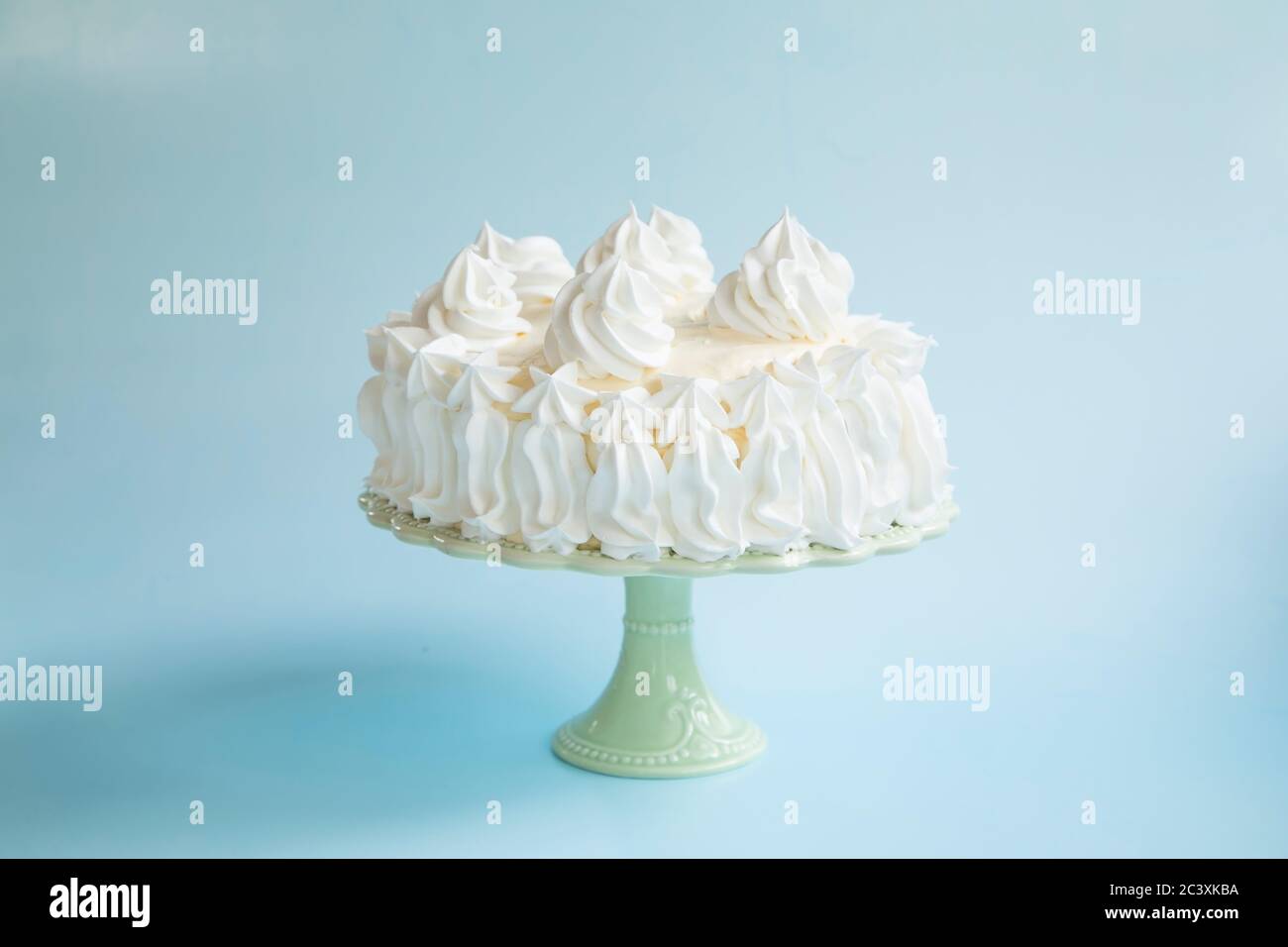Vintage-Kuchen mit Schlagsahne auf grünen Kuchenständer Stockfoto