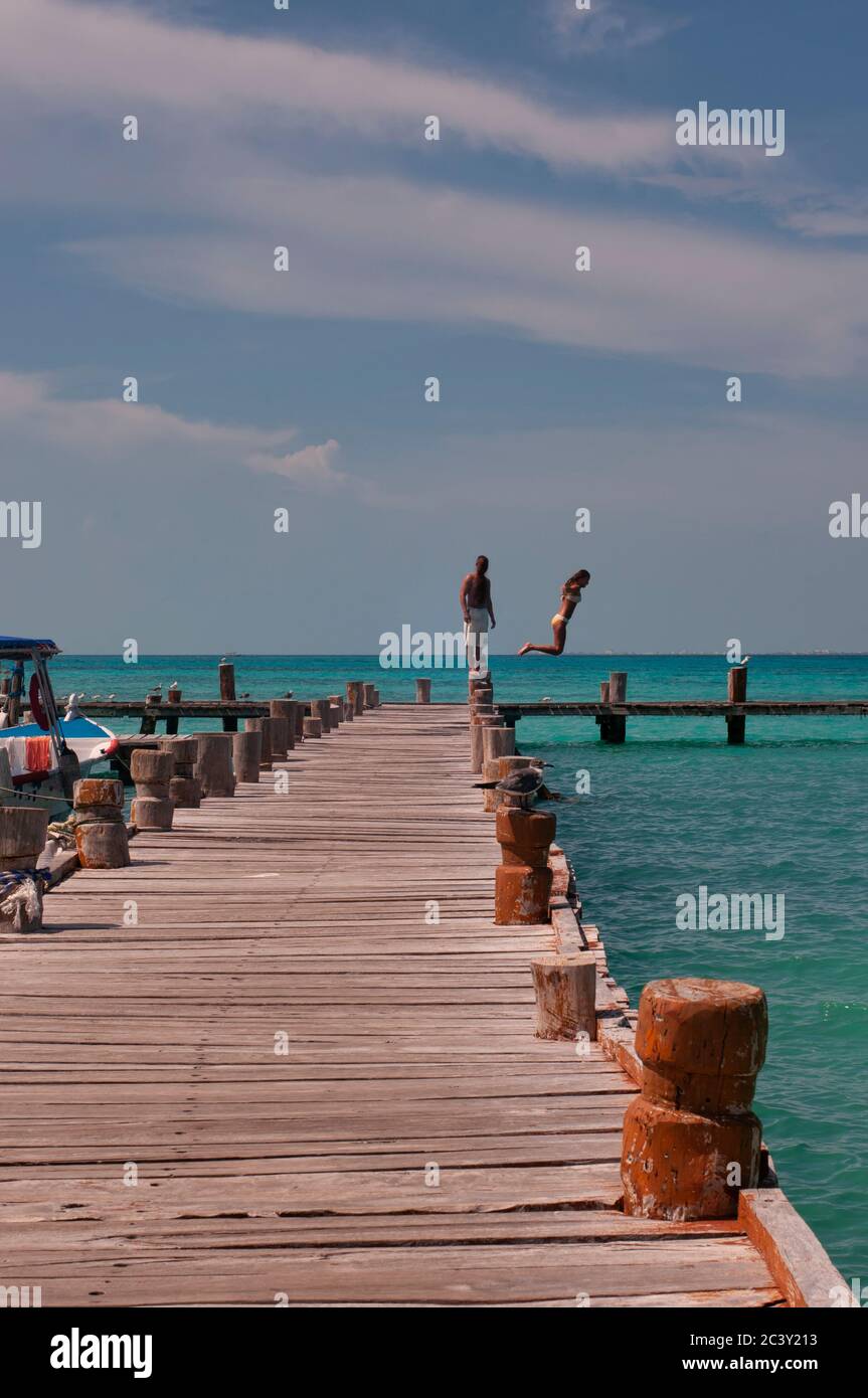 Ein paar Touristen springen ins Meer vom Pier, Karibischen Ozean, Mexiko, Cancun Stockfoto