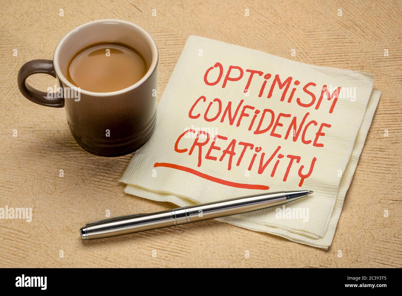 Optimismus, Selbstvertrauen, Kreativität inspirierende Handschrift auf Serviette mit einer Tasse Kaffee, Karriere, Lifestyle und persönlichem Entwicklungskonzept Stockfoto