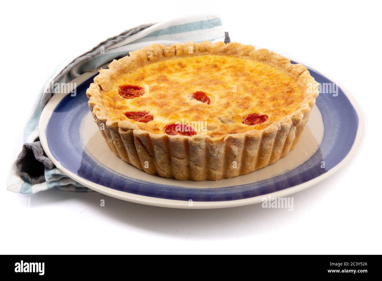 Eine Käsetorte oder Torte mit getrockneten Tomaten in der obersten Kruste isoliert auf weiß Stockfoto