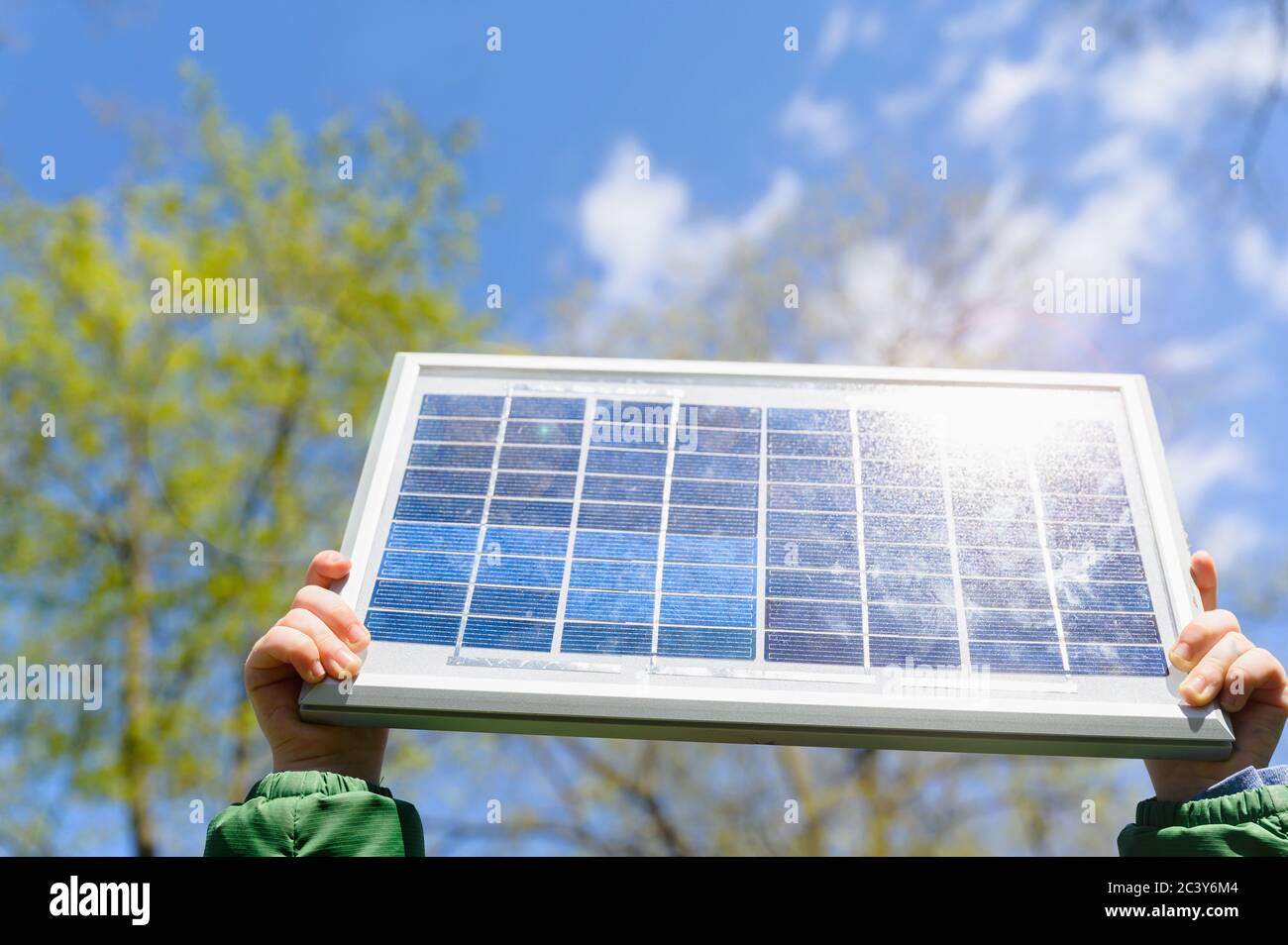 Nahaufnahme von Jungen (4-5) Hände halten Solarpanel gegen den Himmel Stockfoto