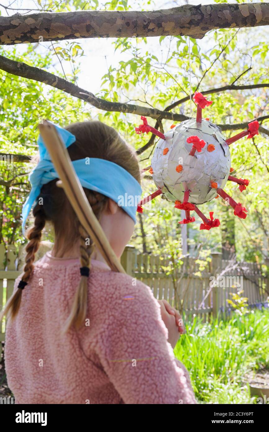 Mädchen (6-7) Vorbereitung auf Coronavirus förmigen Pinata zu treffen Stockfoto