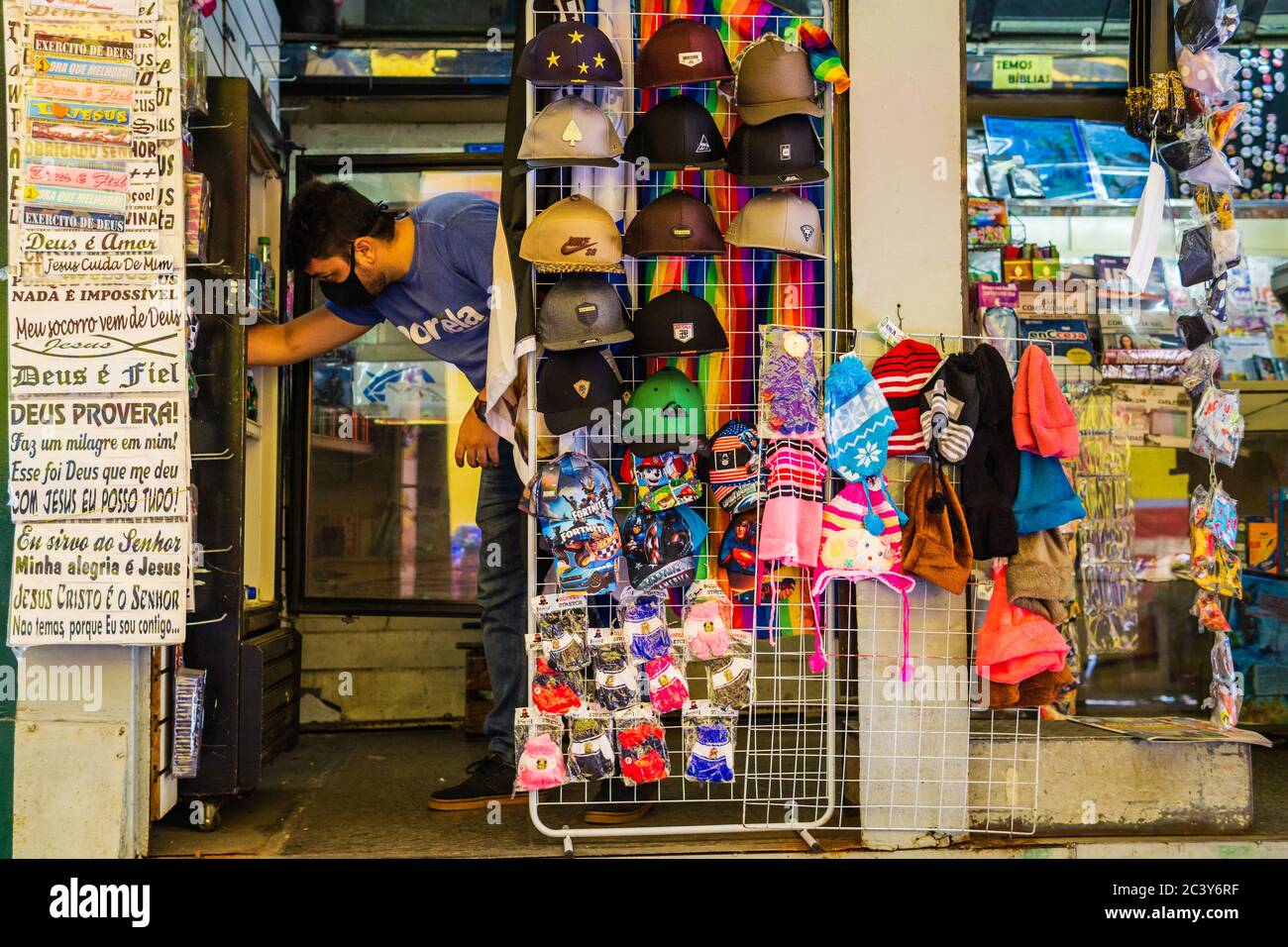 Mann schnappt etwas aus dem Kühlschrank in einem Mini-Laden, der auch als banca de revistas in Belo Horizonte, Brasilien bekannt ist. Stockfoto