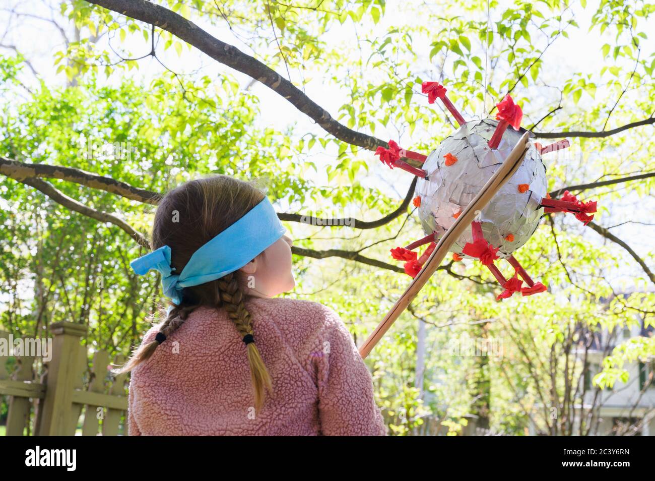 Mädchen (6-7) Schlagen Coronavirus förmigen Pinata Stockfoto
