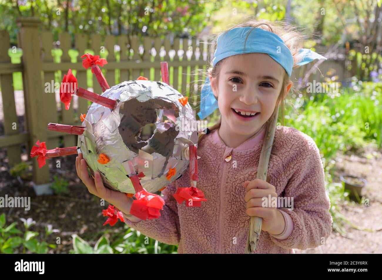 Lächelndes Mädchen (6-7) mit Coronavirus-förmigen Pinata Stockfoto