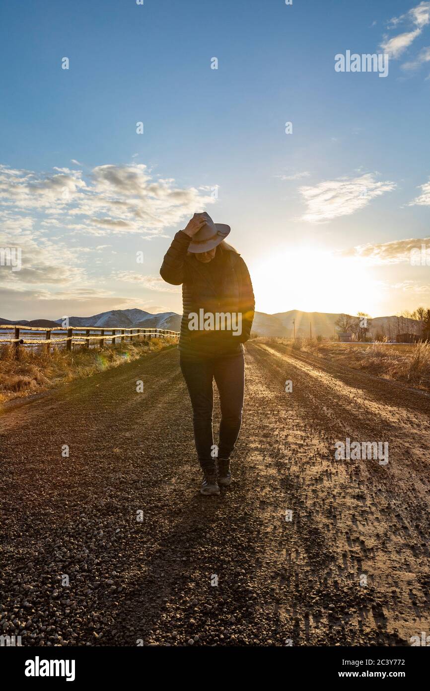 USA, Idaho, Sun Valley, Frau bei Sonnenaufgang auf Landstraße Stockfoto