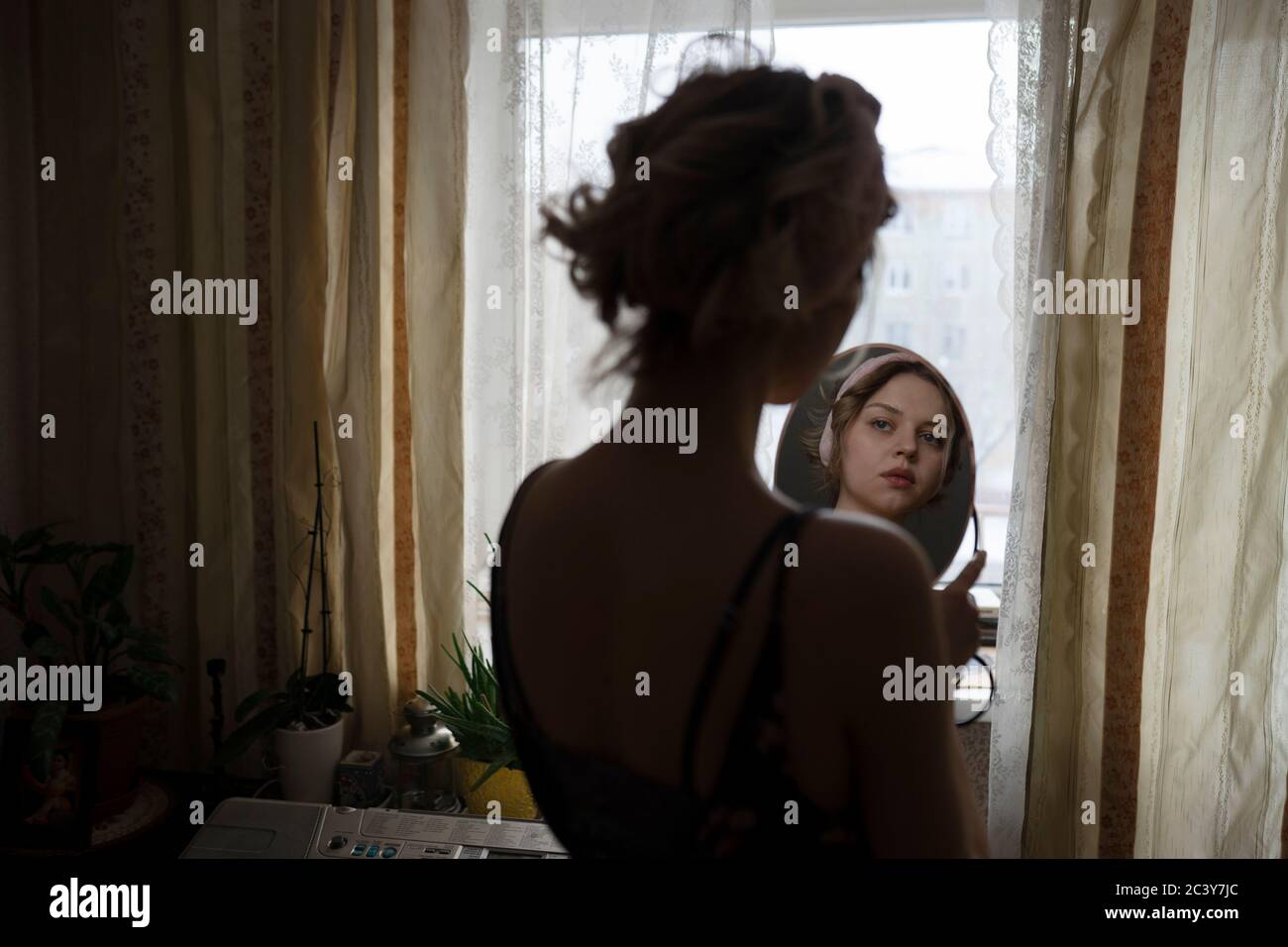 Frau im Spiegel betrachtet Stockfoto