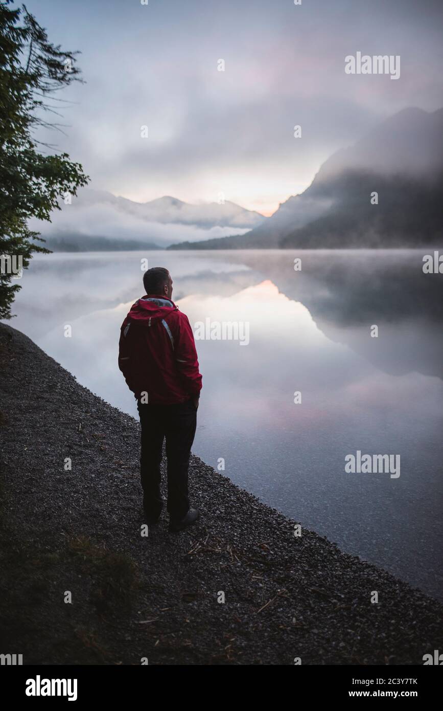 Österreich, Plansee, junger Mann steht bei Sonnenaufgang am Plansee Stockfoto