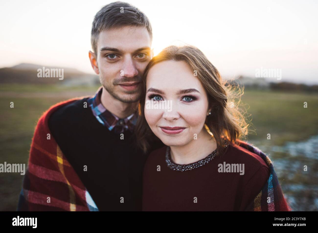 Ukraine, Krim, Junges Paar bedeckt mit Plaid bei Sonnenuntergang Stockfoto