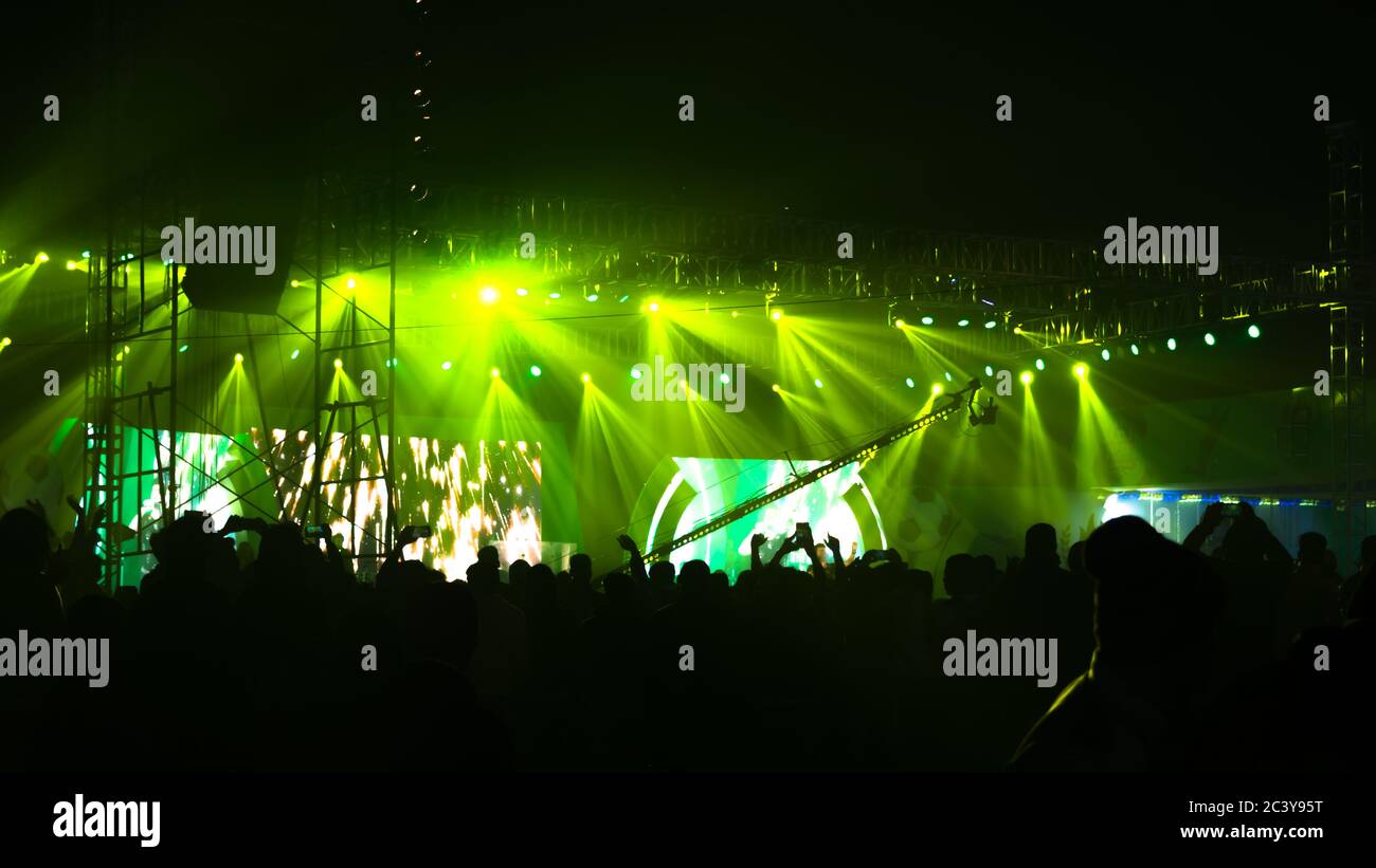 Silhouette Zuschauer Menge Menschen stehen bei Konzert Performance Pop Rock Musik Leben Veranstaltung Preisverleihung vor grünen Farbe Bühne Licht und enjoyin Stockfoto