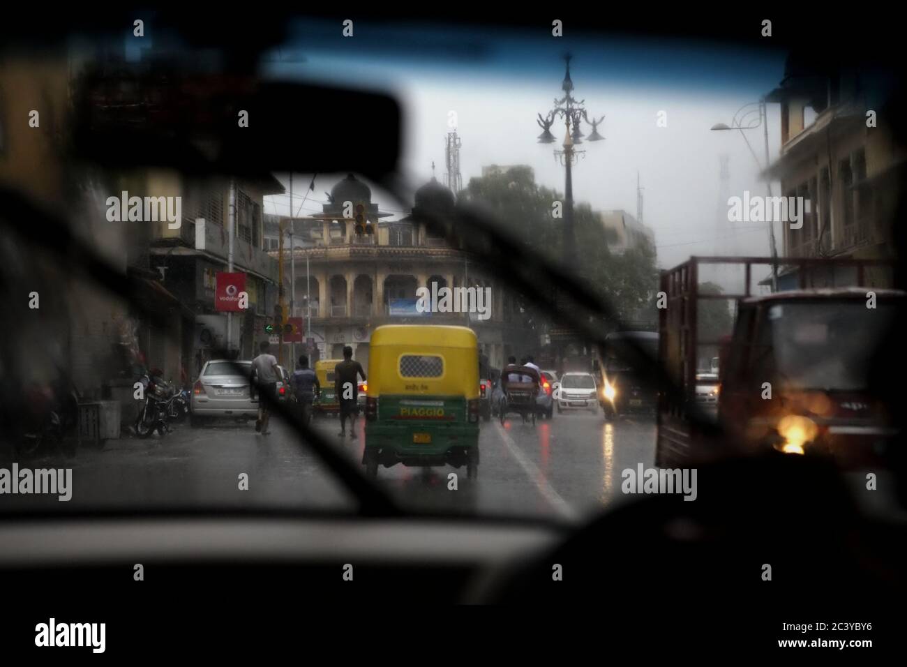 Eine Szene von einem Straßenverkehr aus gesehen von innen ein fahrender Wagen an einem regnerischen Nachmittag in Jaipur, Rajasthan, Indien. Stockfoto