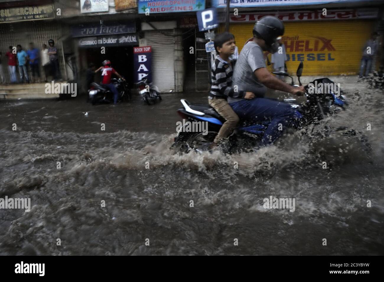 Autofahrer durch eine überflutete Straße unter einem starken Regen in Jaipur, Rajasthan, Indien. Stockfoto