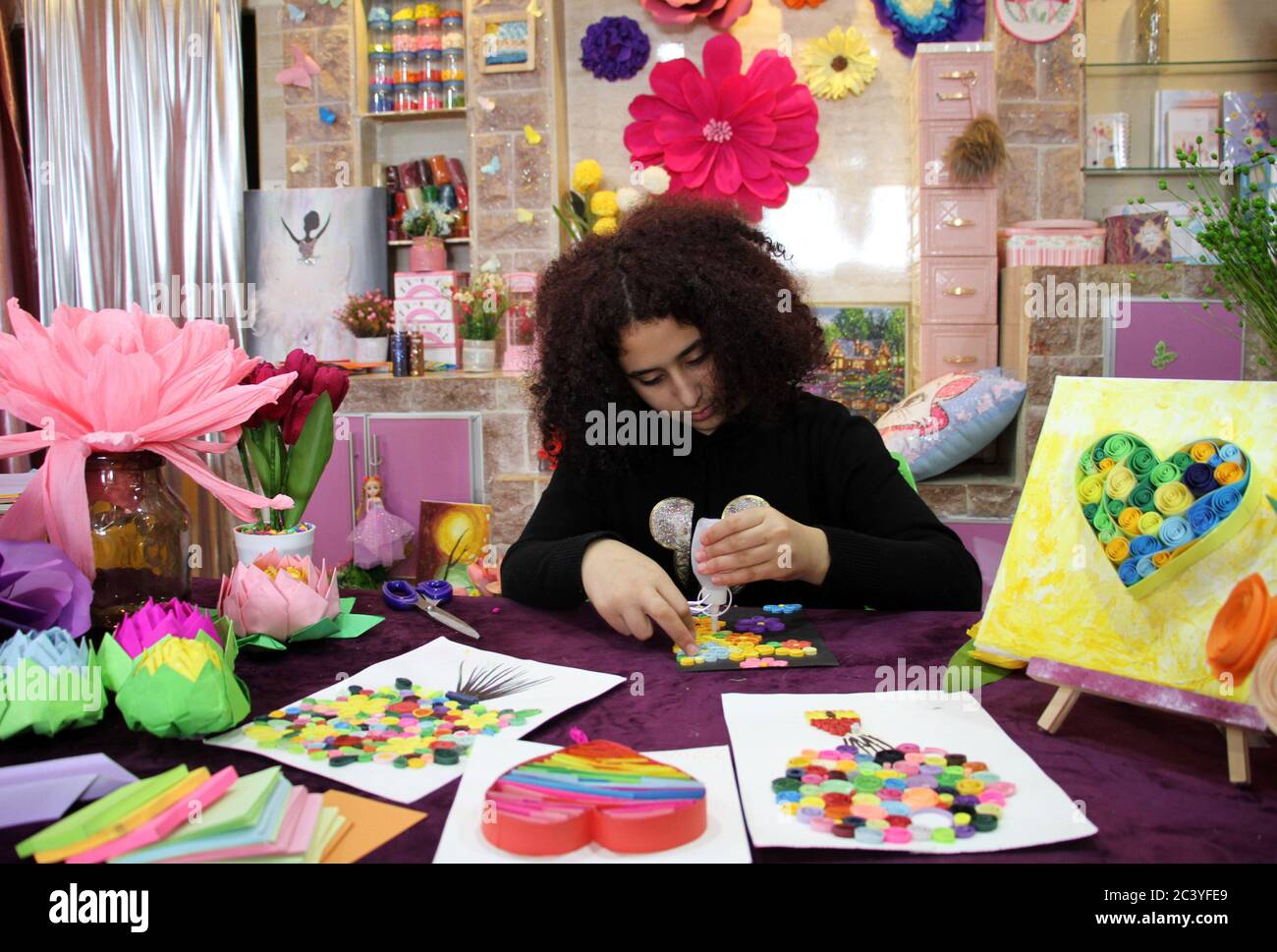 Gaza. Juni 2020. Lina Jabr, 13, macht ein Kunstdesign mit buntem Papier im Flüchtlingslager Nusseirat im zentralen Gazastreifen, 22. Juni 2020. Papierquilling oder Papier filigran ist die Kunst, dünne Papierstreifen in kreisförmige Formen zu Rollen, die zu dekorativen Mustern, ornamentalen Kunstwerken und funktionalen Stücken zusammengeklebt werden. Kredit: Rizek Abdeljawad/Xinhua/Alamy Live Nachrichten Stockfoto