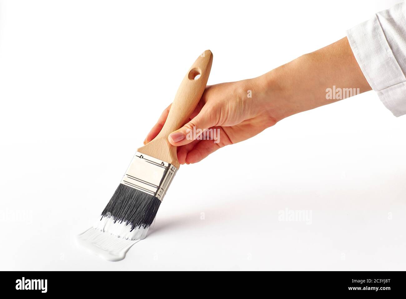 Weibliche Hand malen Mit Pinsel Wandfläche in weißer Farbe. Minimalistische home Reparatur Konzept. Stockfoto
