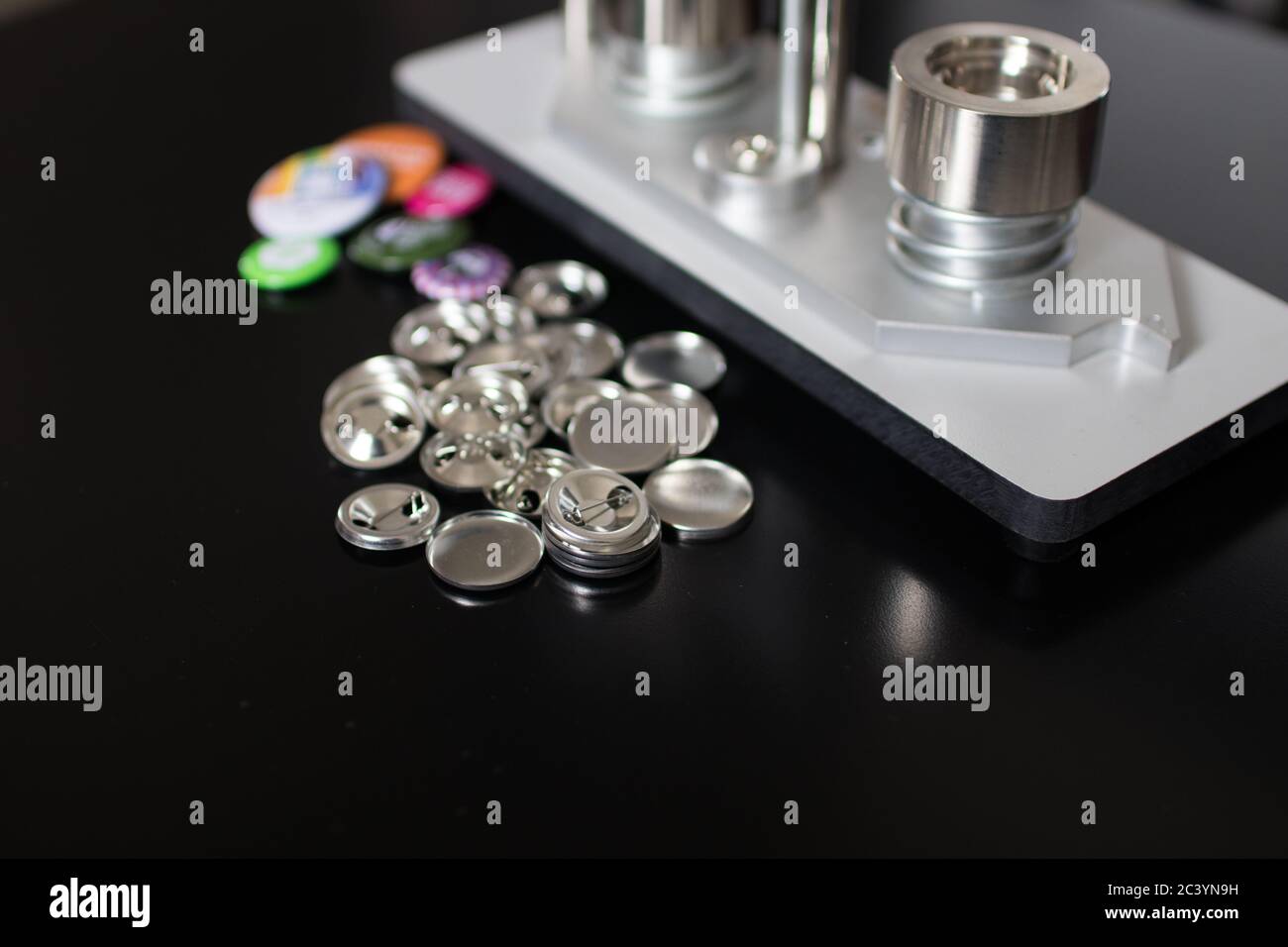 PINs Pressen Maschine mit leeren Pins und fertigen Pins. Druckknopfhersteller für 2,5 cm Abzeichen. Maschine für DIY Mode Knopf, Pins und Magnet Stockfoto