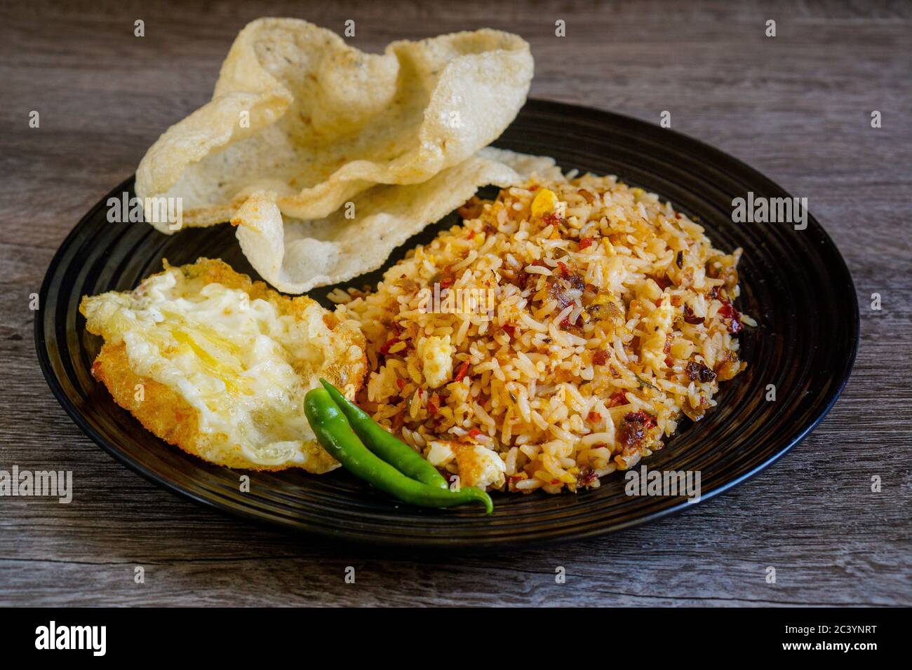 Würziger gebratener Reis mit getrockneter Chili mit Spiegelei und Fischkracker. Stockfoto
