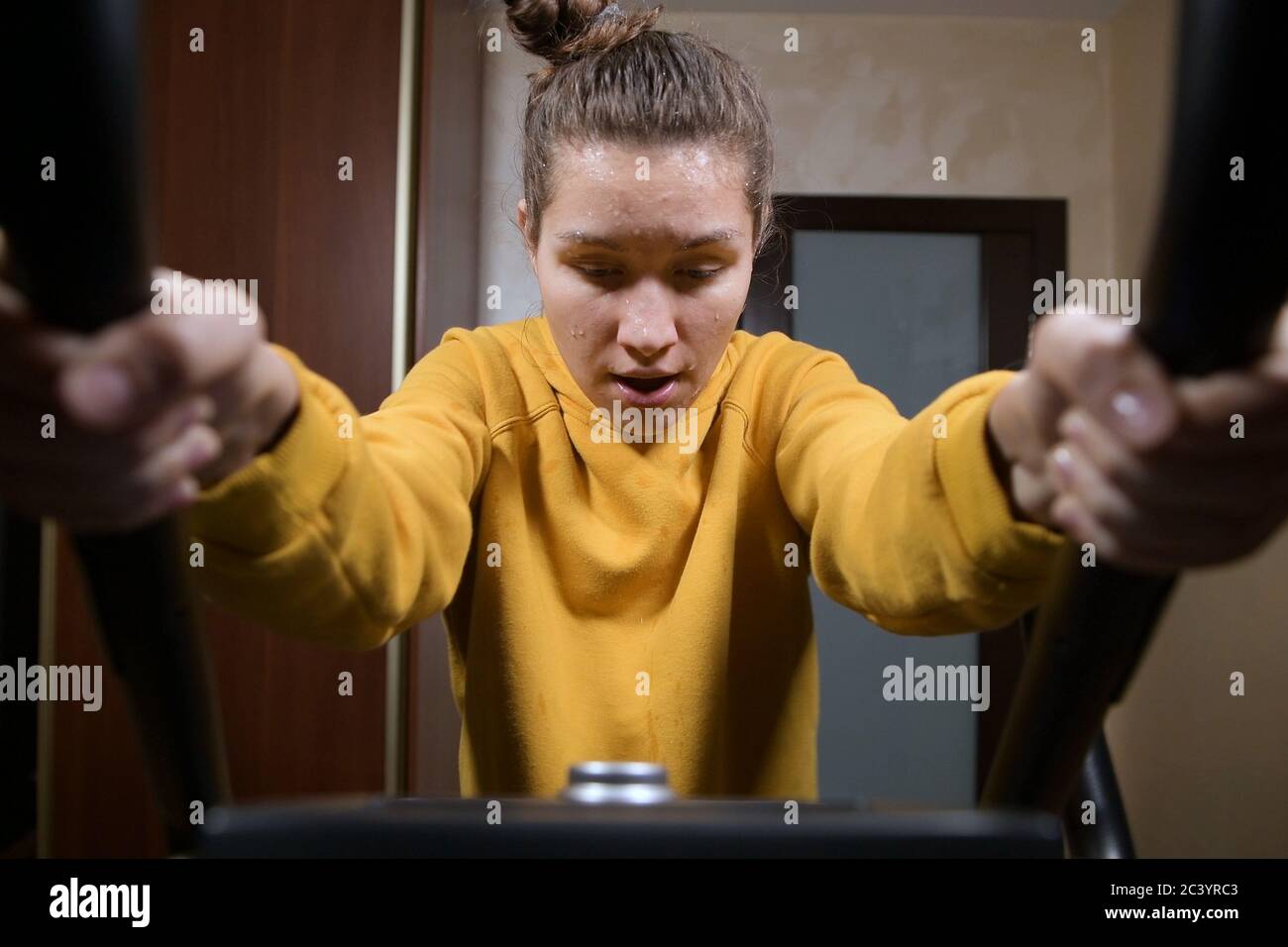 Mädchen verliert während des Trainings Kraft und rutscht den Sport nach unten Trainingsgerät Stockfoto