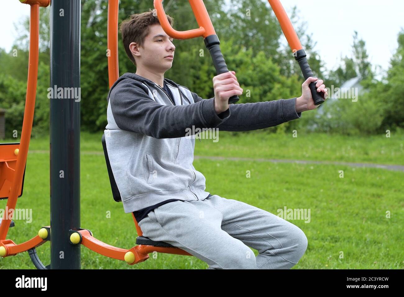 Ein Teenager trainiert auf einer Sportmaschine mit dem eigenen Gewicht eines Athleten. Stockfoto