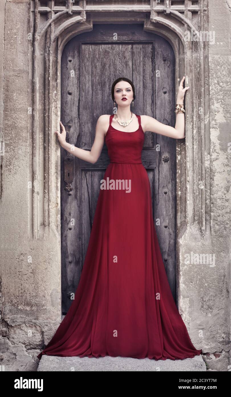 Schöne Frau in rotem Kleid, in der Nähe der klassischen Architektur Stockfoto