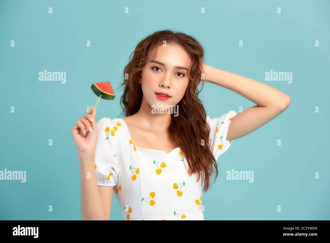 Junge asiatische Frau hält eine Wassermelone geschnitten. Sommerstimmung Stockfoto