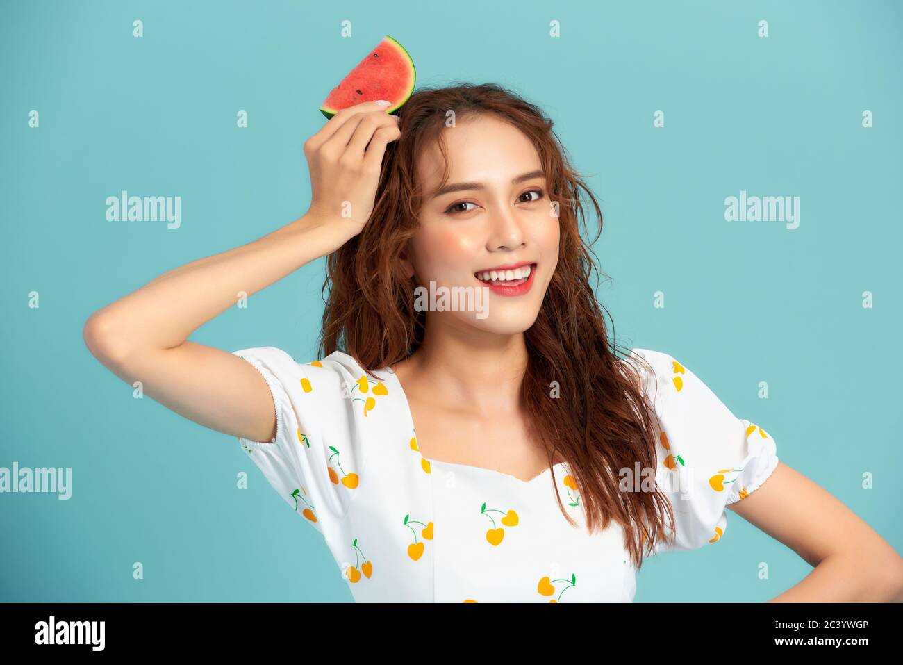 Junge asiatische Frau hält eine Wassermelone geschnitten. Sommerstimmung Stockfoto