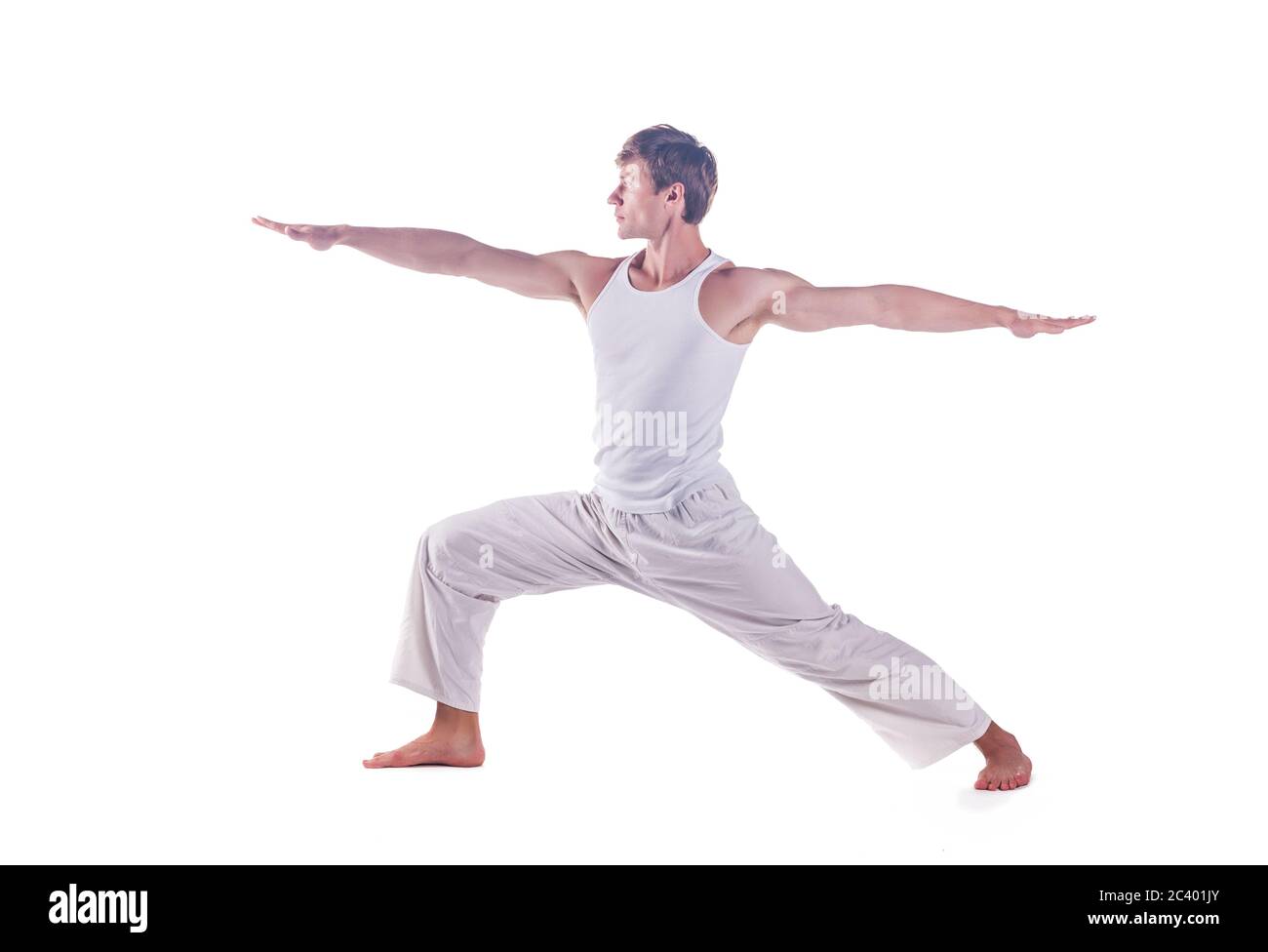 Mann, der Yoga praktiziert, indem er die Haltung des Kriegers 2 übt. Virabhadrasana 2, Stockfoto