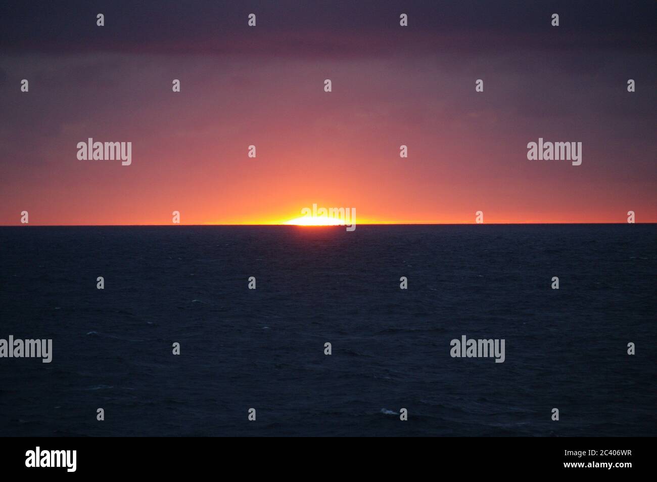 Bildfolge eines Sonnenuntergangs vom gleichen Aussichtspunkt, Sonnenuntergang im Meer, Skyline bei Dämmerung, Abenddämmerung Horizont über dem Meer Magenta Skyline Stockfoto